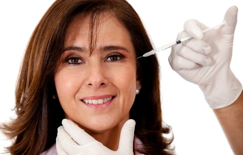 Woman getting a face lift with Botox - isolated over a white background